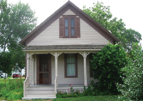 Tan sided building with dark brown shutters.