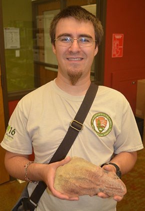 G. William M. Harrison holding a fossilized shark egg case.