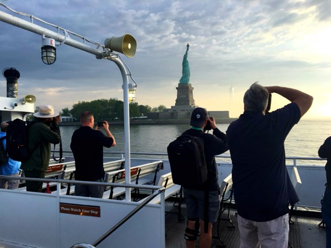 Wounded Warriors taking photos of the Statue of Liberty from the ferry.