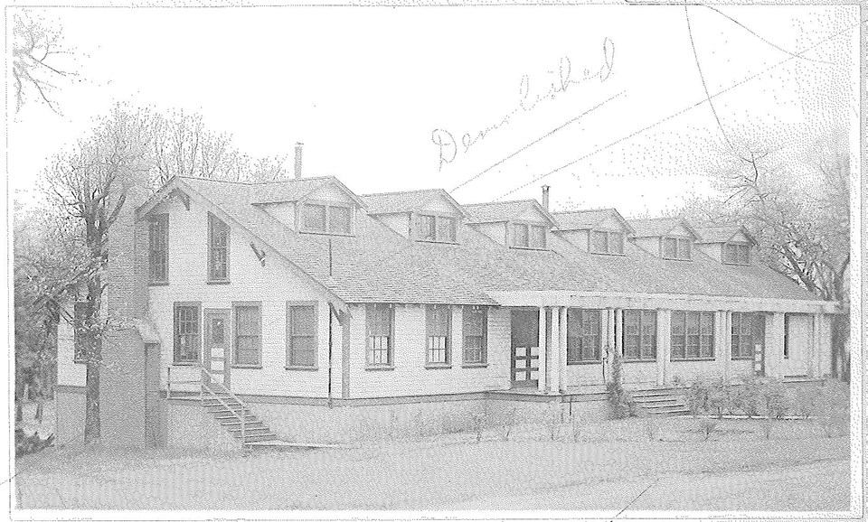 YMCA QM records - for web Black and white photo of a rectangular building with chimney, windows, and a porch.