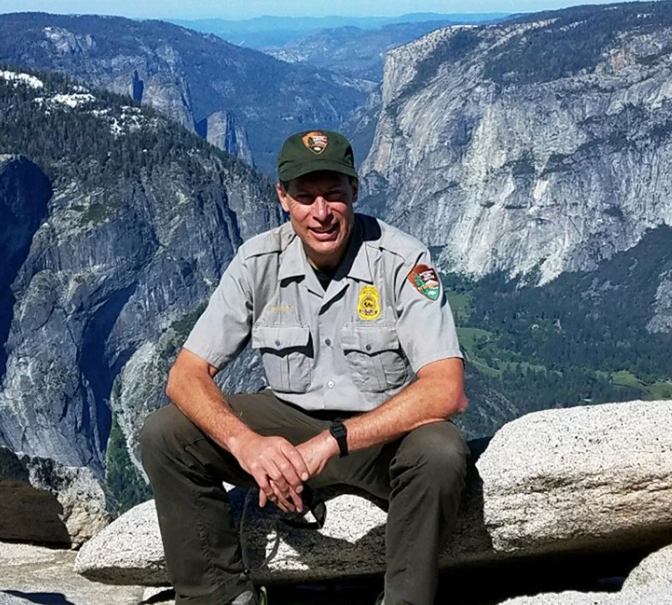 Jack Hoeflich sitting on a scenic canyon overlook