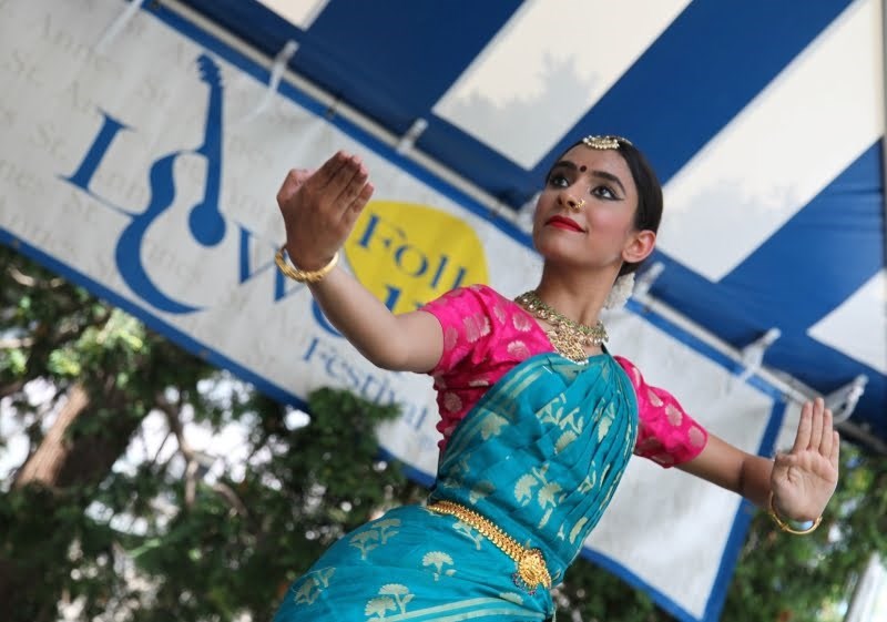 Yamini Kalluri and the Carnatic Ensemble A woman in Indian clothing and jewelry dances.