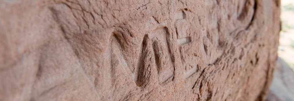 carved letters in a sandstone surface