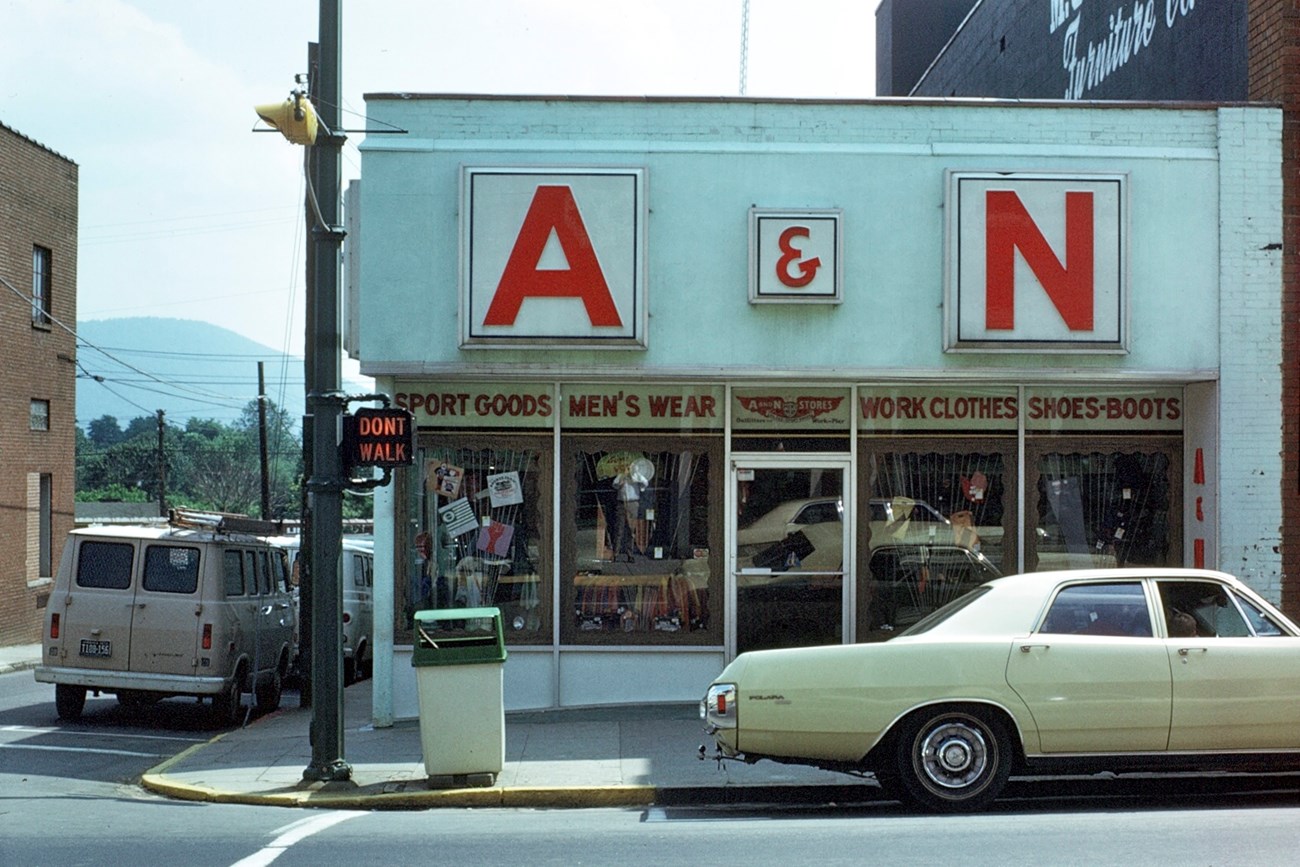 Historic view of a mid-century storefront and car