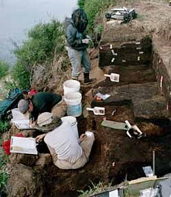 [photo] Three archeologists working along river bank.