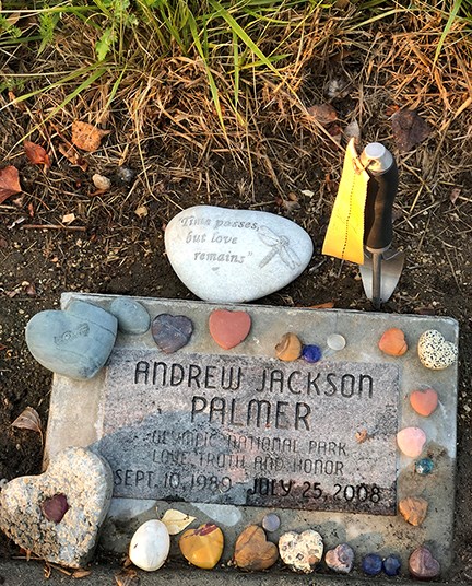 Memorial stone for Andy Palmer decorated with stone hearts.