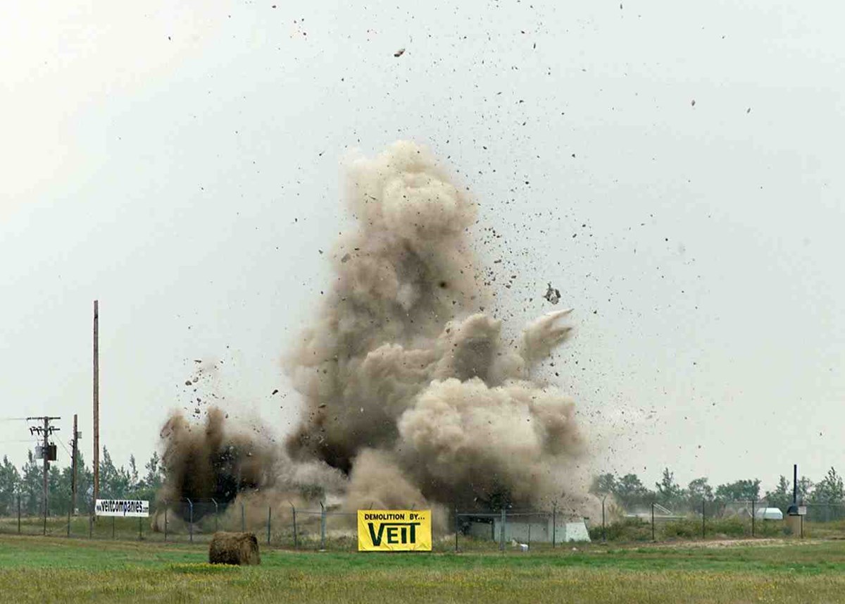 Smoke and debris rise from a fenced compound where a missile silo was once located