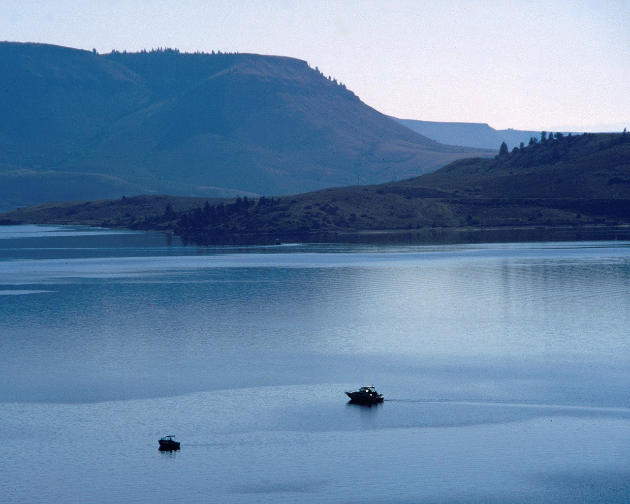 two boats float in blue reservoir