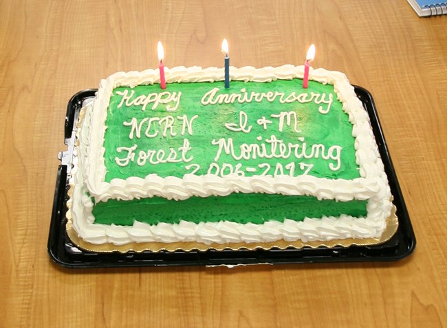 A sheet cake with candles reads: Happy Anniversary, NCRN I&M, Forest Monitoring 2006-2017