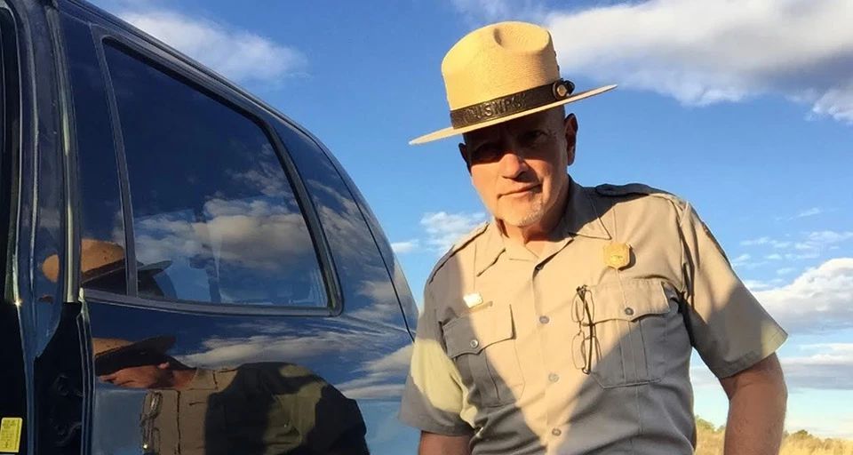 a ranger in uniform with flat, straw hat
