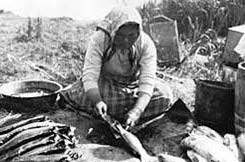 An Alutiiq woman cleans fish in this historic photo. An Alutiiq woman cleans fish in this historic photo.