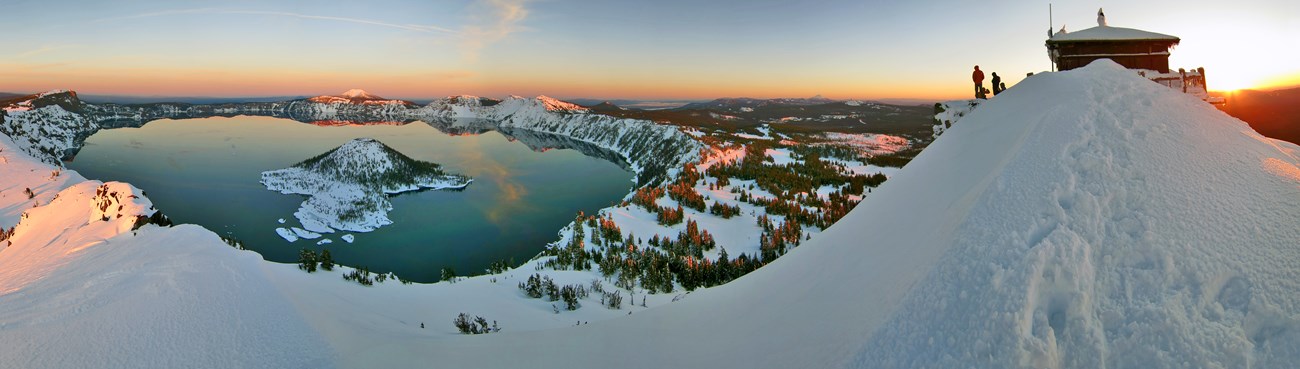 panoramic image of crater lake with snow