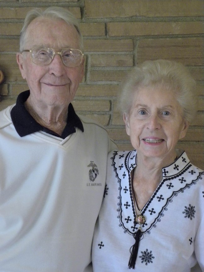 a white haired man and woman smile for the camera