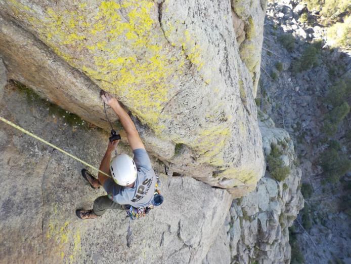 View from above of a climber suspended on the side of Devils Tower