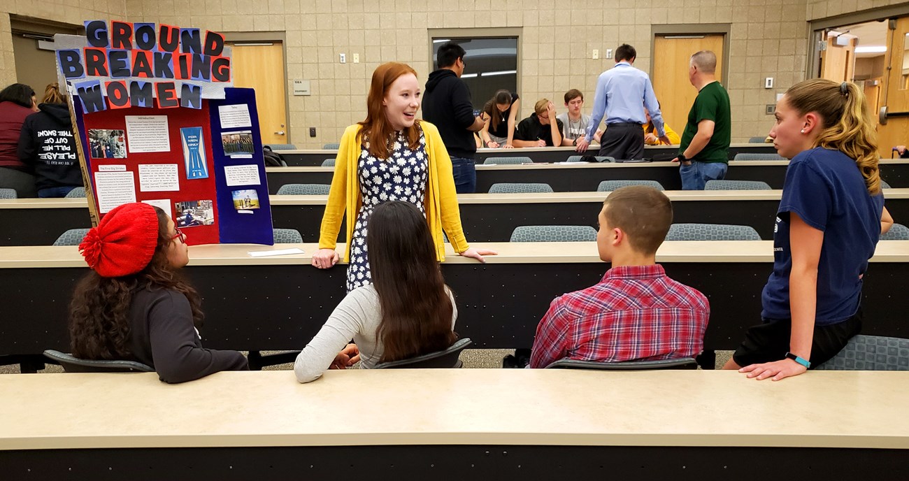 A college student talks to high school students about "Ground Breaking Women." A college student talks to high school students about "Ground Breaking Women."