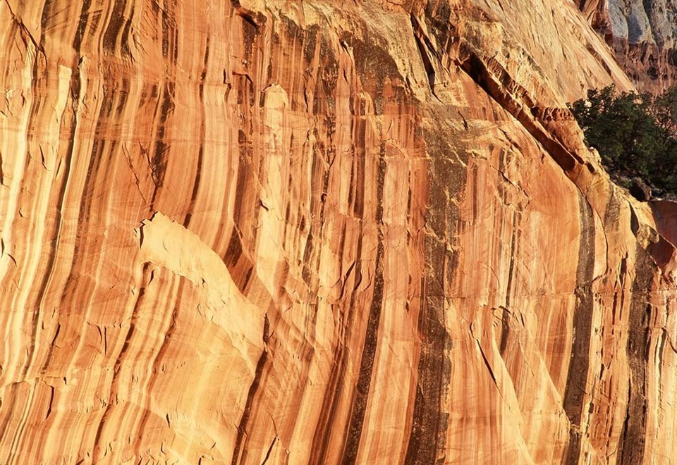 black streaks of desert varnish on a red rock wall