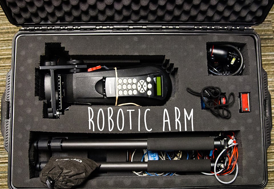 liwei_deskdigs_roboticarm a long camera arm with several buttons on it inside a large padded briefcase