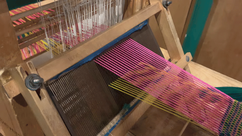 shedding gif pink and yellow yarns laid out in a row are alternatingly lifted up and down