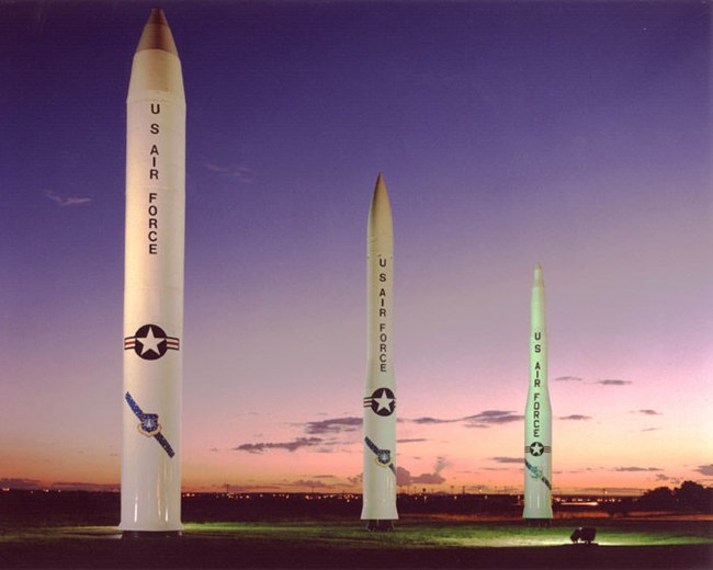 Three large missile models at sunset
