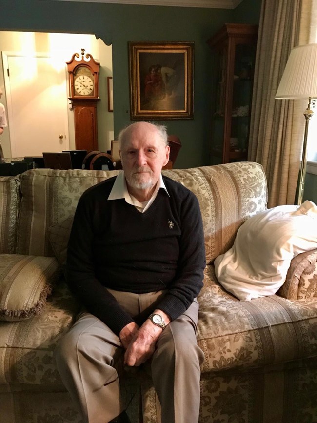 well dressed elderly man sitting on a couch