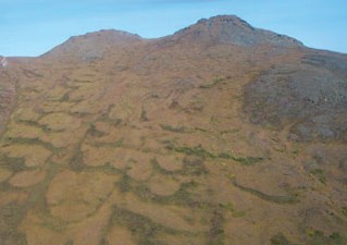 tree-less mountainside with rippled pattern to the ground