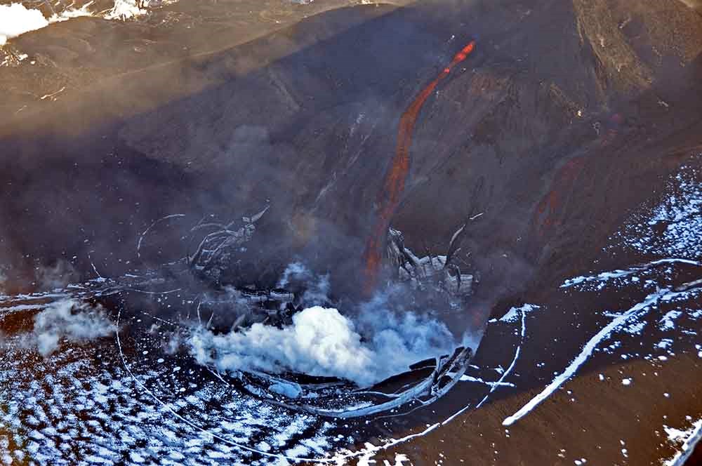 Lava runs down into the volcanic crater.