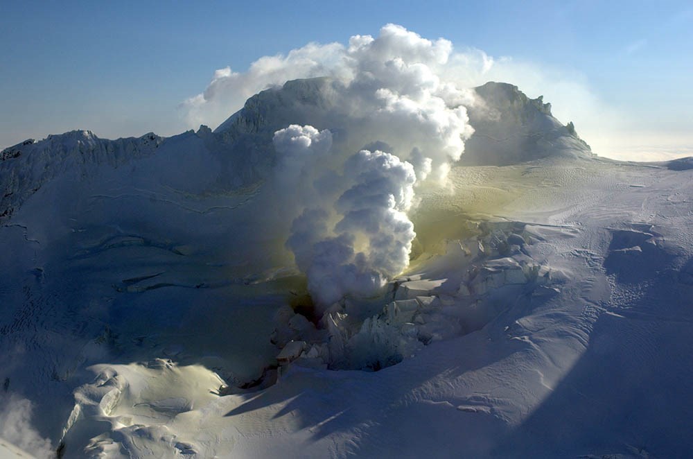 A fumarole on Fourpeaked Mountain in the winter turns the snow yellow.