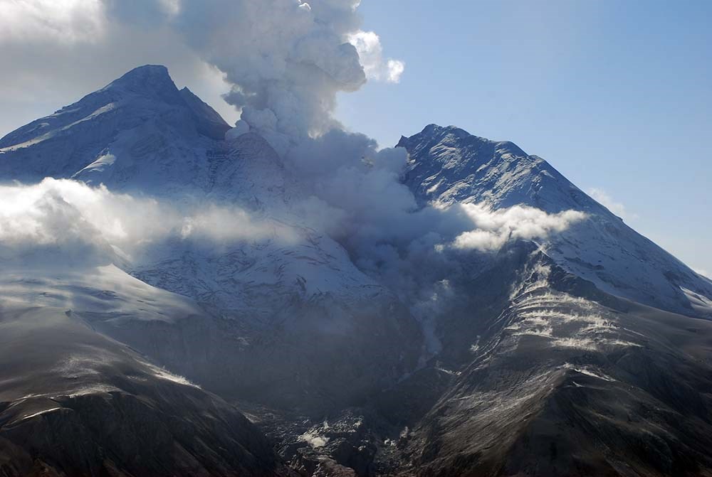 Redoubt Volcano erupting with ash clouds rising.