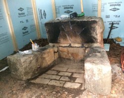 lt= a stone firepit surrounded by blue temporary walls and tools