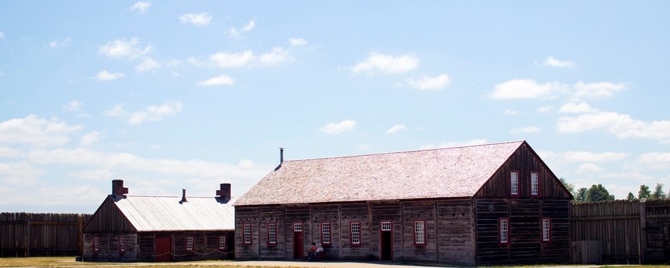 Photo of a wooden rectangular building along the fort's stockade wall