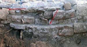 The south wall of the spring enclosure after excavation. The left arrow points to the outlet in the improved spring enclosure, the right arrow to the top of the old spring enclosure. Photograph courtesy of Emily J. Brown. The south wall of the spring enclosure after excavation. The left arrow points to the outlet in the improved spring enclosure, the right arrow to the top of the old spring enclosure. Photograph courtesy of Emily J. Brown.