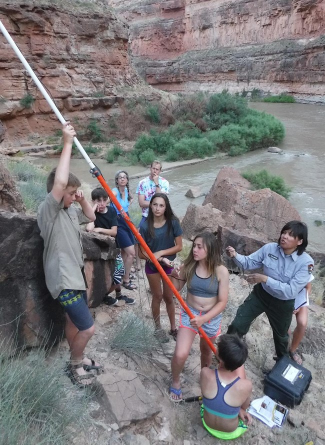 A group of youths help set up acoustic monitoring with a ranger