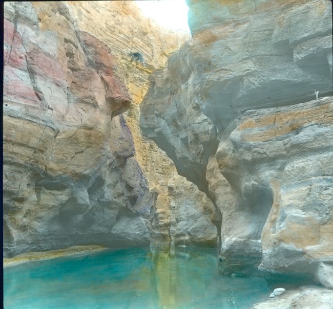 Beaver canyon water. Sand-colored stone surrounds a pool of clear blue water.