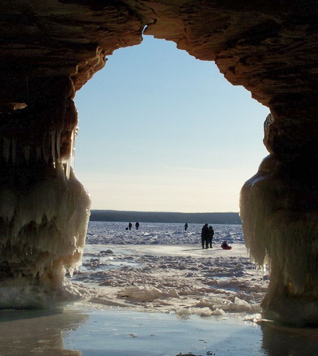 cave opening to frozen lake