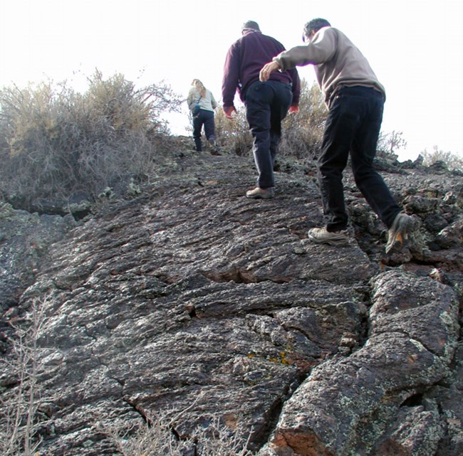 visitors walking on lava rock