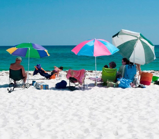 people and umbrellas on white sand beach
