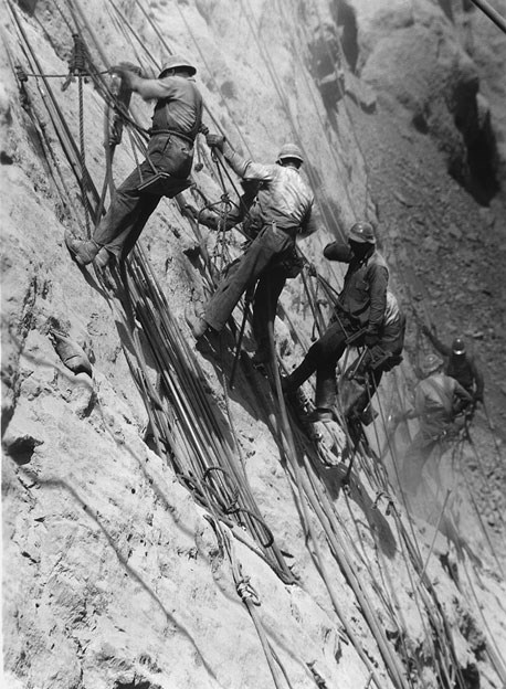 Men rappelling down side of the Hoover Dam.