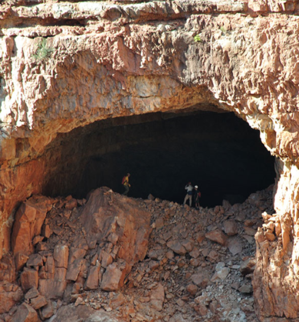 People at an entrance to a large cave People at an entrance to a large cave