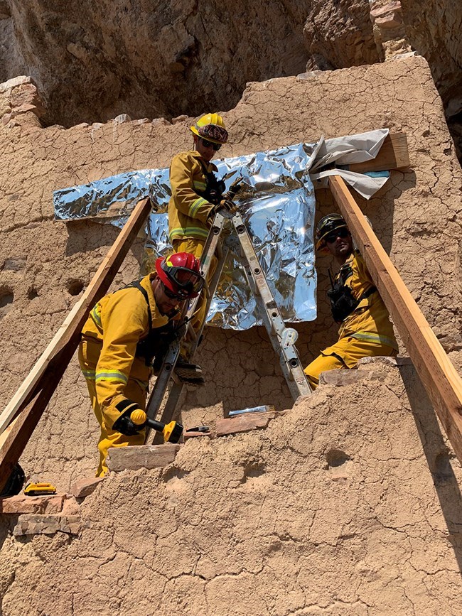 Crew wraps modern wood in the cliff dwelling Crew wraps modern wood in the cliff dwelling