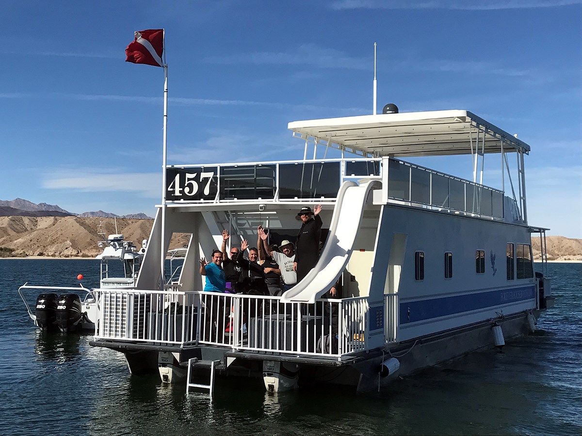 divers wave from houseboat