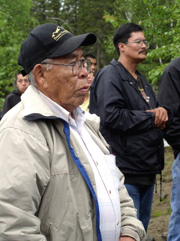 alaska native elder standing near other people outdoors