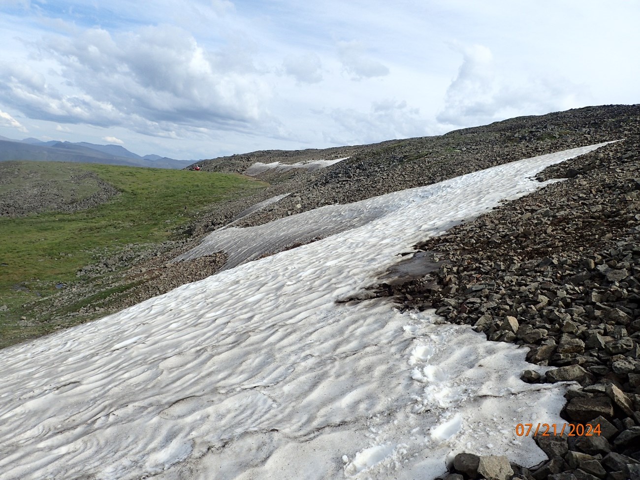 Snow and ice covers a portion of a rocky slope, in a photo dated 07/21/2024.