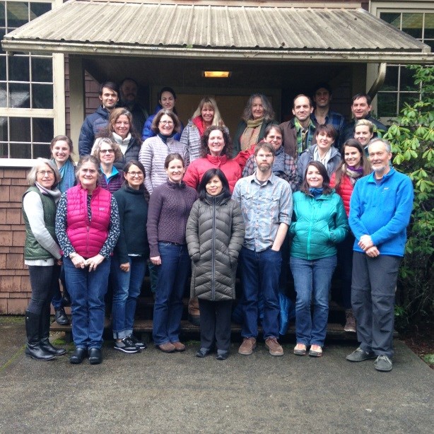 Training group A couple dozen people stand at a building entrance for a photo