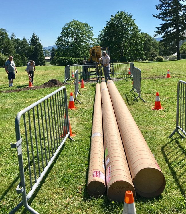 Large sections of metal flagpole rest on the ground.