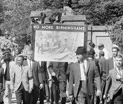 people walking in a street with a sign reading "No More Birminghams"