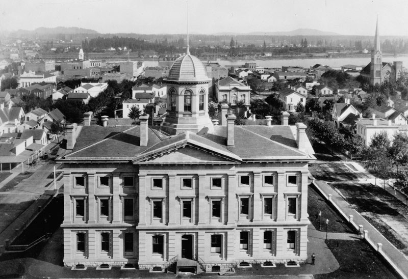 Aerial of a three story courthouse with cupola.
