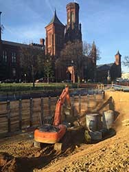 Digging in National Mall Turf a machine digs in the dirt in front of the smithsonian castle