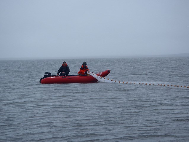 two researchers in a small boat collecting data about a lagoon
