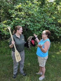 two adults with canoe paddle and toy dog