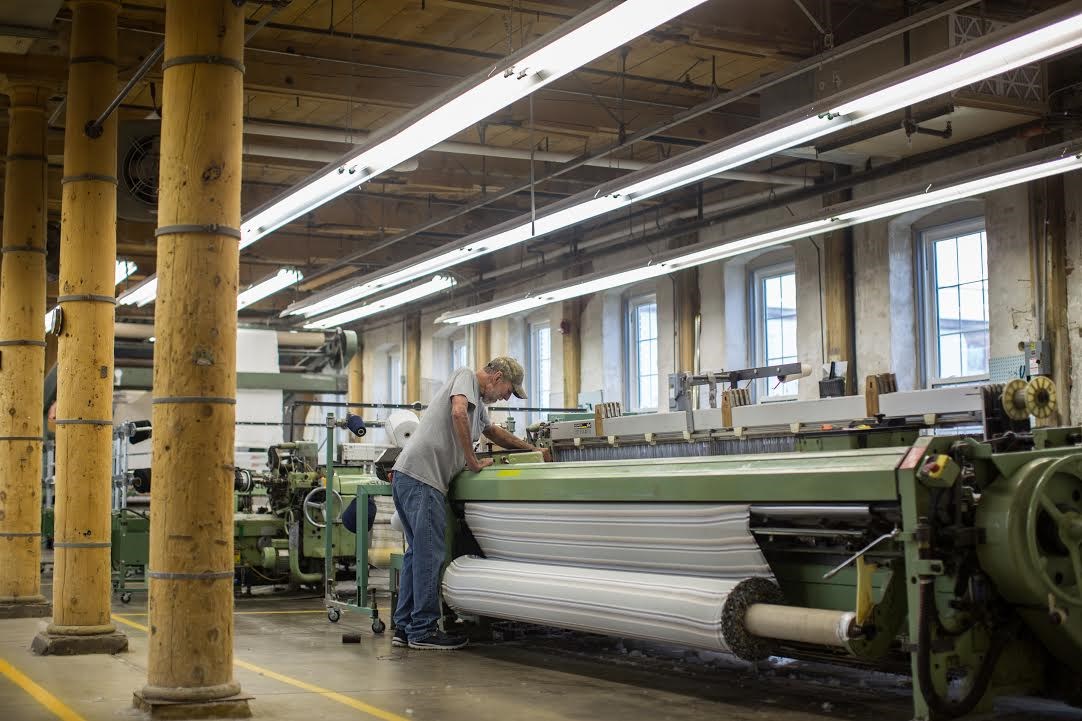 man working at loom at woolen mill